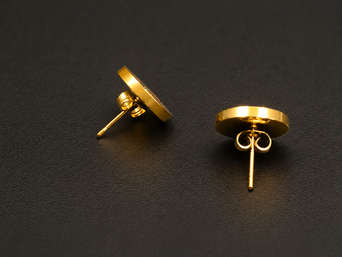 Two gold stud earrings shown on a dark textured background, displaying both the flat circular face and the butterfly back.