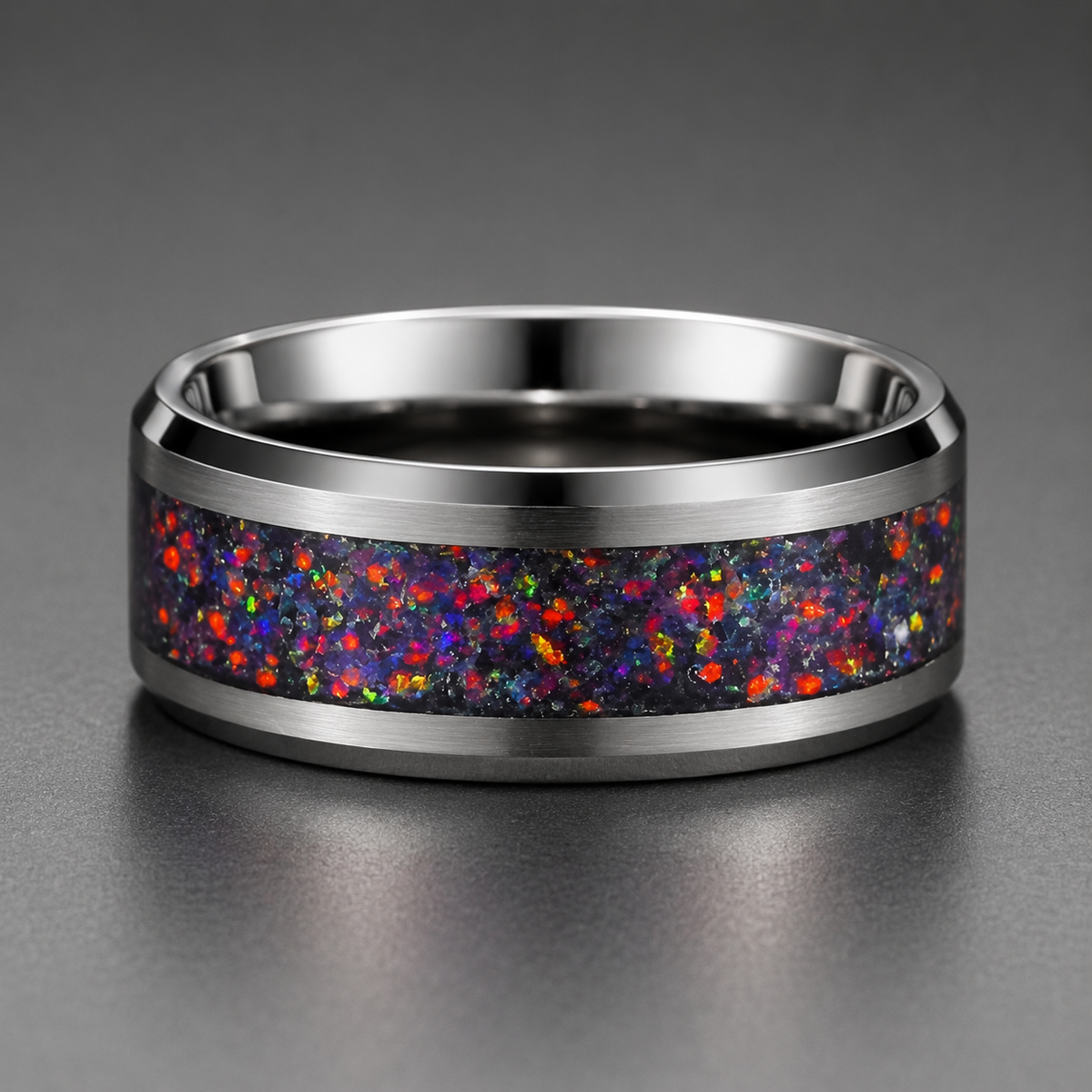 Silver ring with a colorful speckled band on a gray background