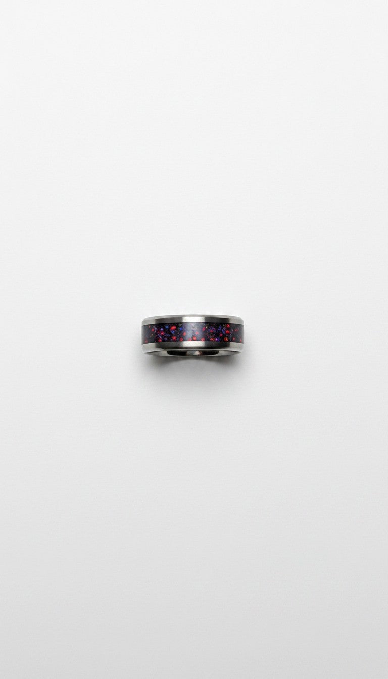 Silver ring with red and black design on a white background